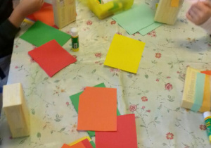 dzieci robią instrumenty z pudełek, kolorowego papieru i ryżu